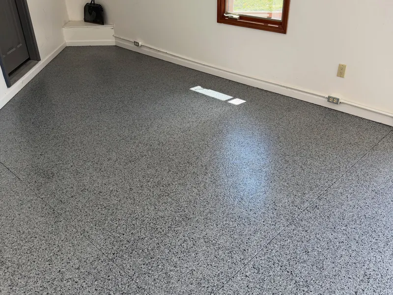 Bright room with a glossy gray flake floor and a window on the far wall